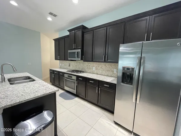 a kitchen with a refrigerator sink and cabinets