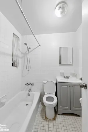 a bathroom with a toilet a sink a mirror and bathtub