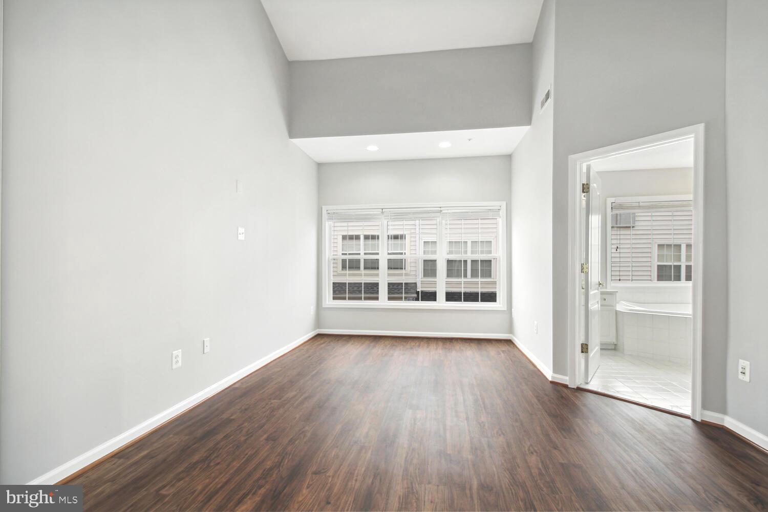 10258 Rutland Round Road, Unit 13 Columbia, MD 21044 - Photo 14 of 24 an empty room with wooden floor and windows