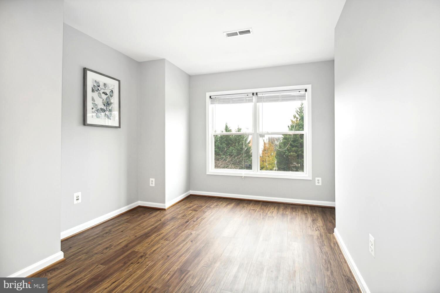 10258 Rutland Round Road, Unit 13 Columbia, MD 21044 - Photo 16 of 24 an empty room with wooden floor and windows