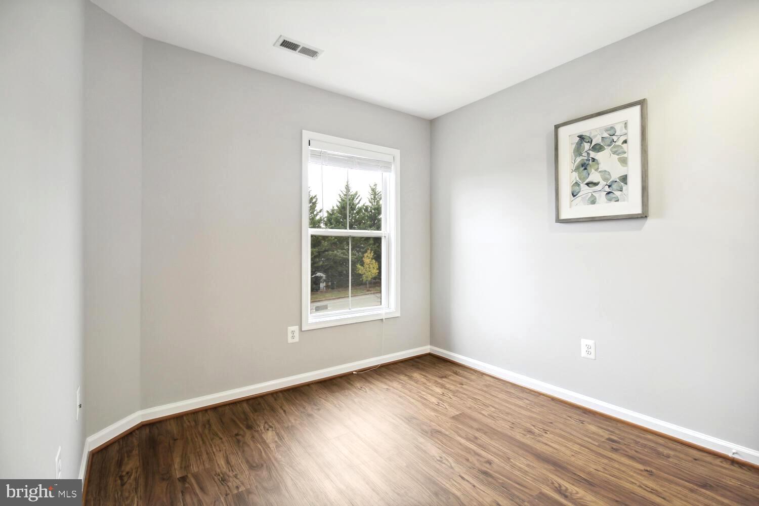 10258 Rutland Round Road, Unit 13 Columbia, MD 21044 - Photo 18 of 24 an empty room with wooden floor and windows