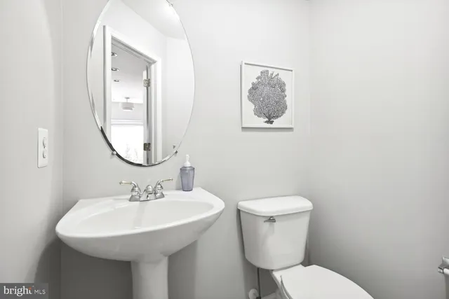 a bathroom with a toilet a sink and a mirror