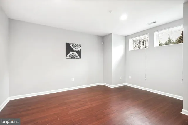 a view of an empty room with wooden floor