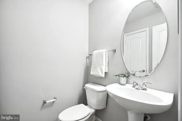 a bathroom with a sink toilet and mirror