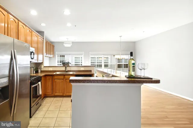 a kitchen with stainless steel appliances granite countertop a sink and a refrigerator