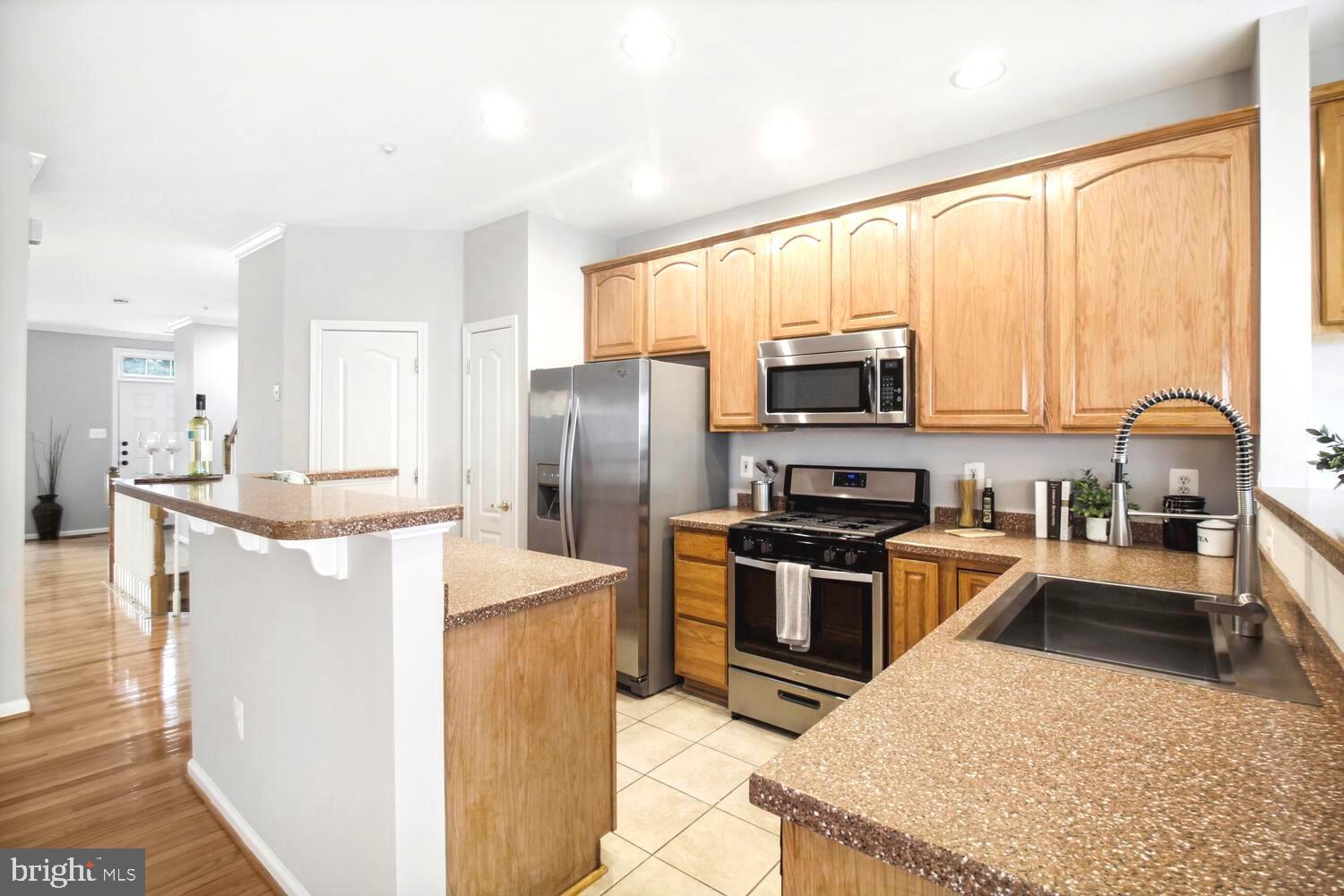 10258 Rutland Round Road, Unit 13 Columbia, MD 21044 - Photo 9 of 24 a kitchen with stainless steel appliances granite countertop a refrigerator stove top oven and sink