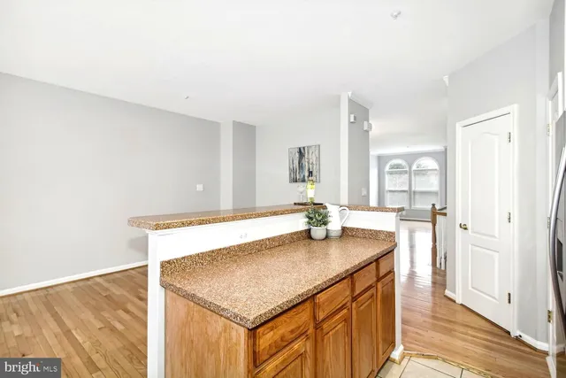 a kitchen with stainless steel appliances granite countertop a sink and a wooden floor
