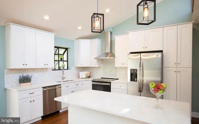 a kitchen with stainless steel appliances white cabinets and wooden floor