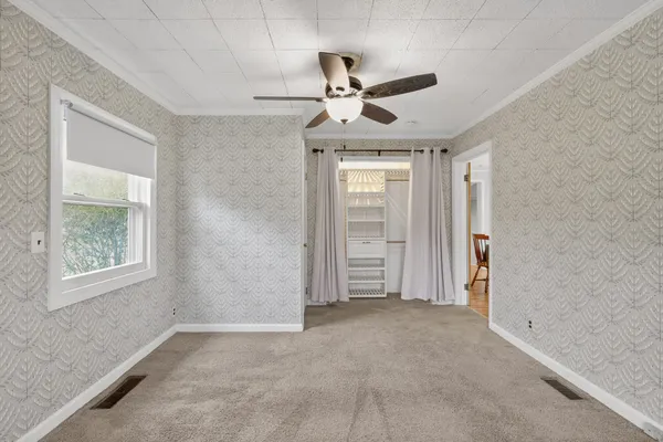an empty room with closet and windows