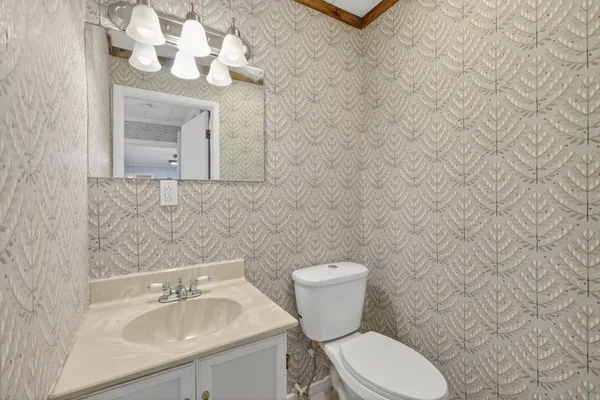 a bathroom with a toilet sink and mirror