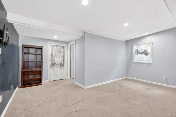 a view of an empty room with closet and a window