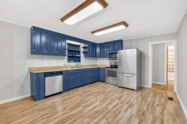 a kitchen with a refrigerator sink and wooden cabinets