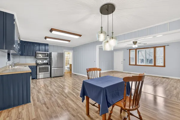 a view of a dining room with furniture a chandelier and wooden floor