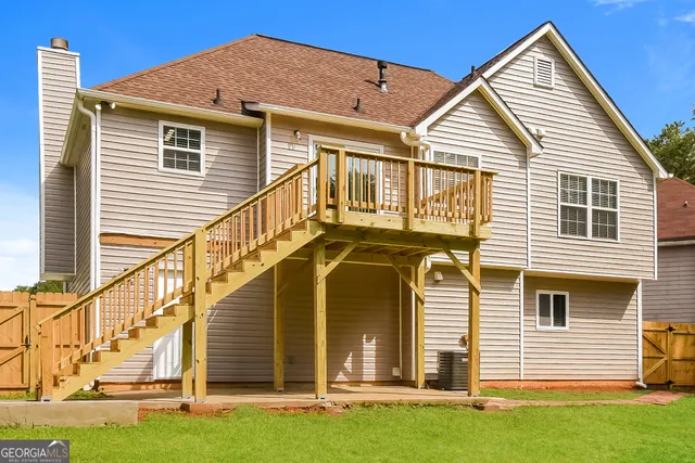 a view of a house with wooden stairs and a small yard