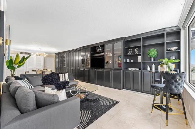 a living room with furniture a flat screen tv and a potted plant