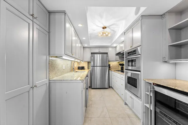 a dining room with furniture a kitchen view and a chandelier