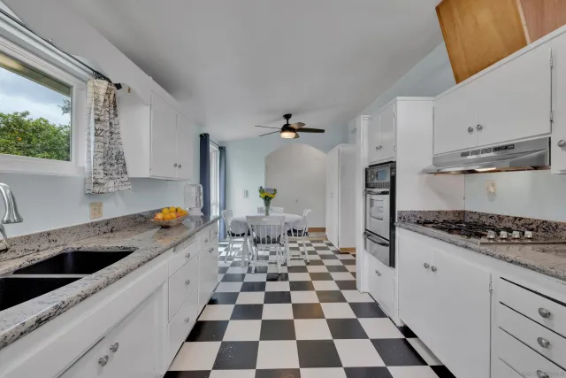 a kitchen with a checkered floor and white appliances