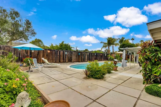a view of a patio with a table and chairs and a barbeque