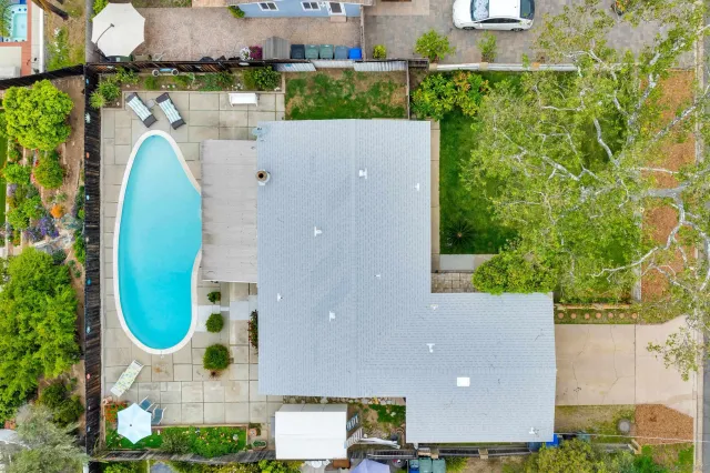 an aerial view of a house with a swimming pool a yard and outdoor seating