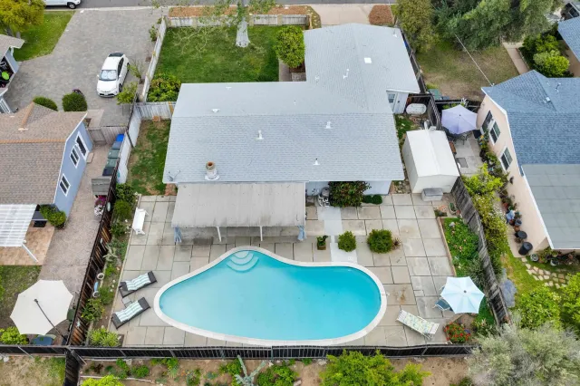 an aerial view of a house with swimming pool and patio