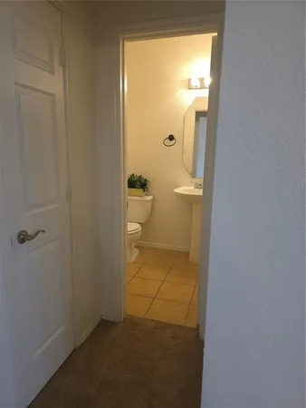 a bathroom with a granite countertop sink and a toilet