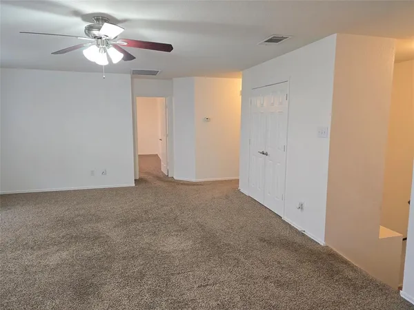 a view of a room with a ceiling fan and a window