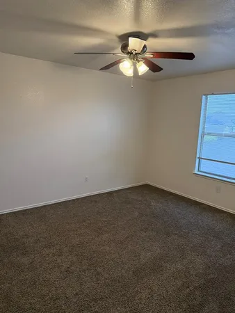 a view of an empty room with a chandelier fan