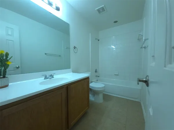 a bathroom with a granite countertop sink a toilet and shower