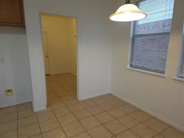 an empty room with a table and chandelier