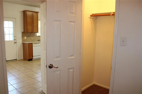 a view of a hallway with a white cabinet and a bathroom