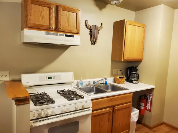 a white kitchen with a stove and a sink