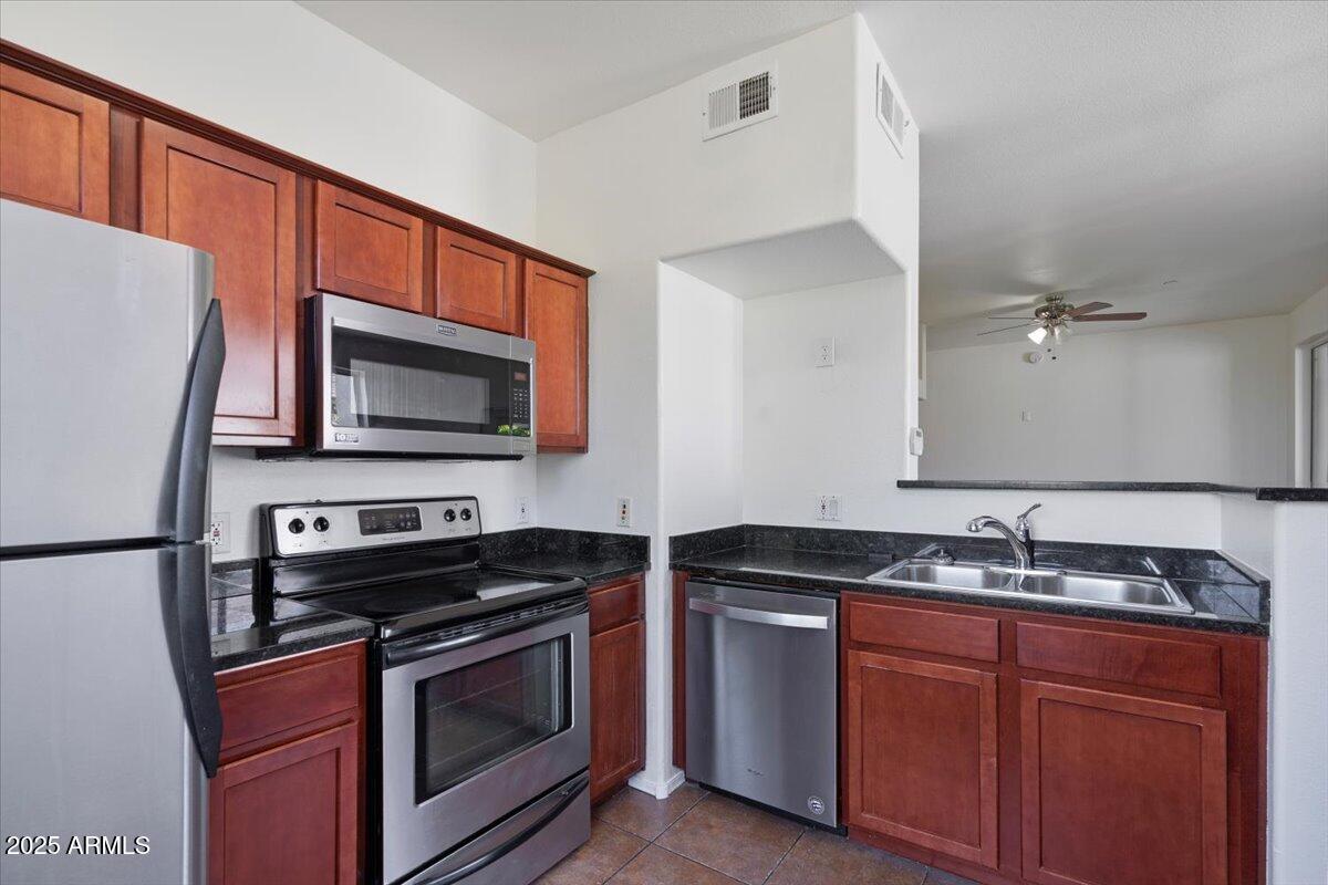 3302 North 7th Street, Unit 319 Phoenix, AZ 85014 - Photo 12 of 28 a kitchen with stainless steel appliances a stove a sink and a microwave