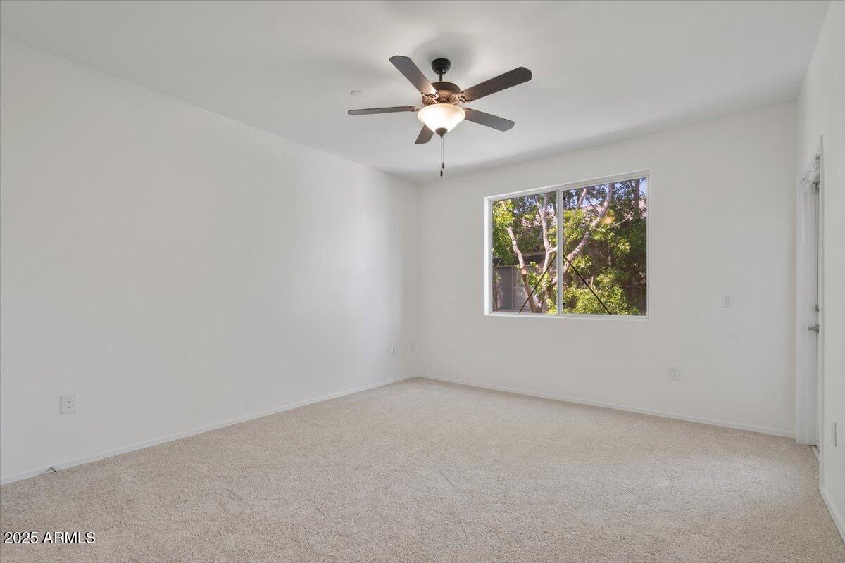 3302 North 7th Street, Unit 319 Phoenix, AZ 85014 - Photo 6 of 28 an empty room with window and ceiling fan