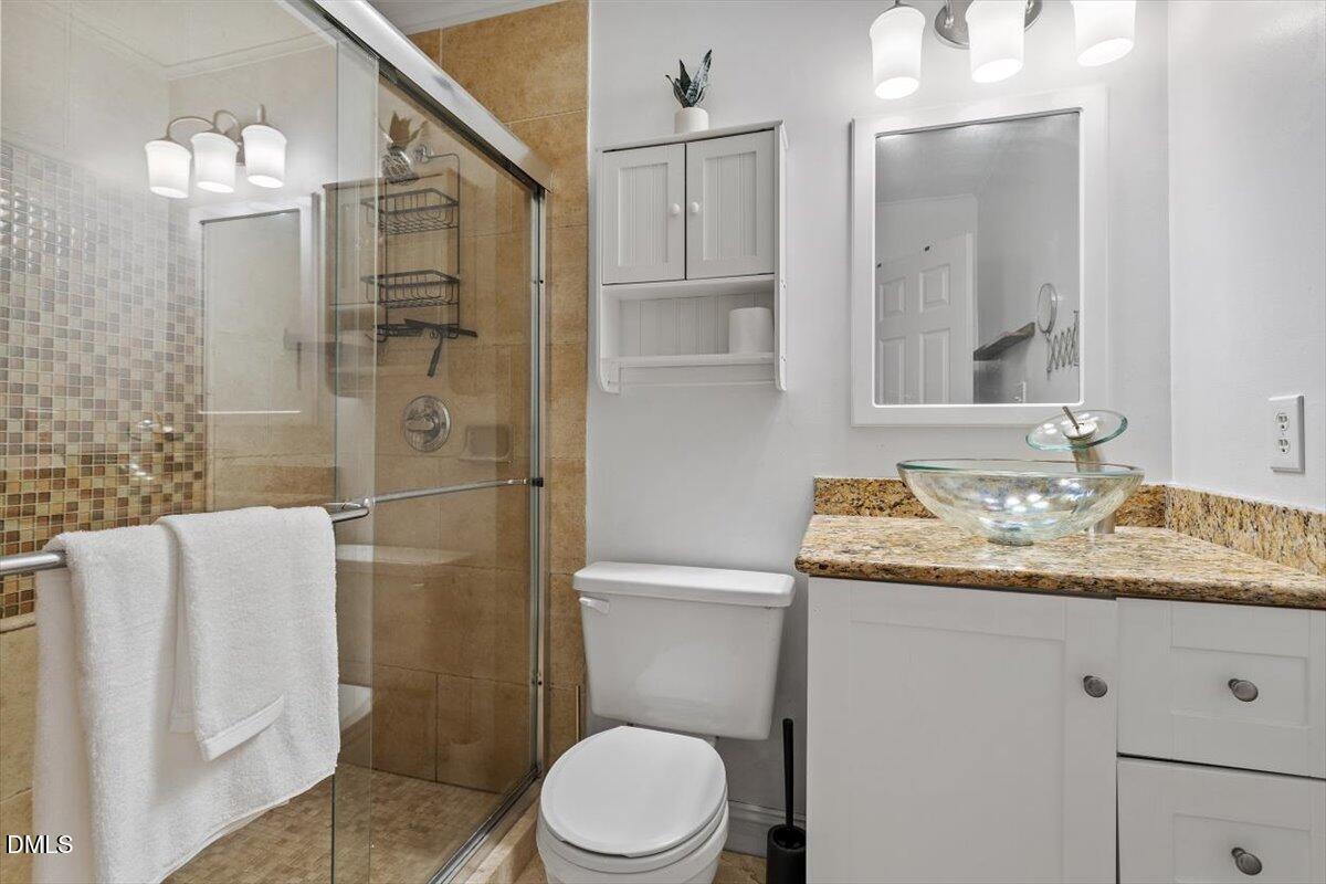 1007 Castalia Drive Cary, NC 27513 - Photo 12 of 30 a bathroom with a granite countertop sink toilet and shower