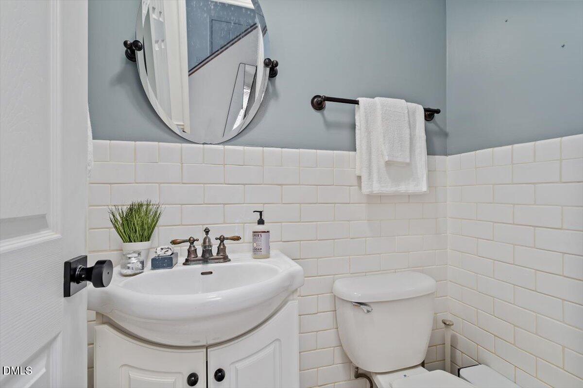 1007 Castalia Drive Cary, NC 27513 - Photo 14 of 30 a bathroom with a sink a toilet and mirror