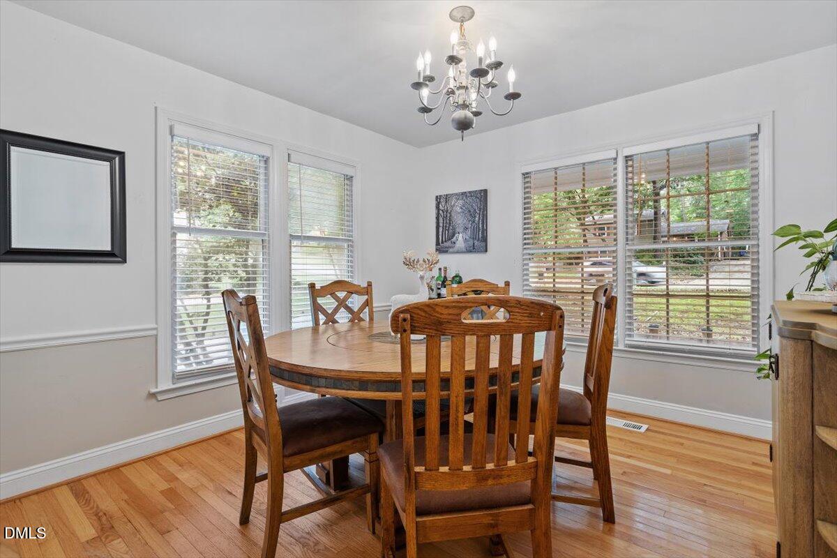 1007 Castalia Drive Cary, NC 27513 - Photo 15 of 30 a view of a dining room with furniture window and wooden floor