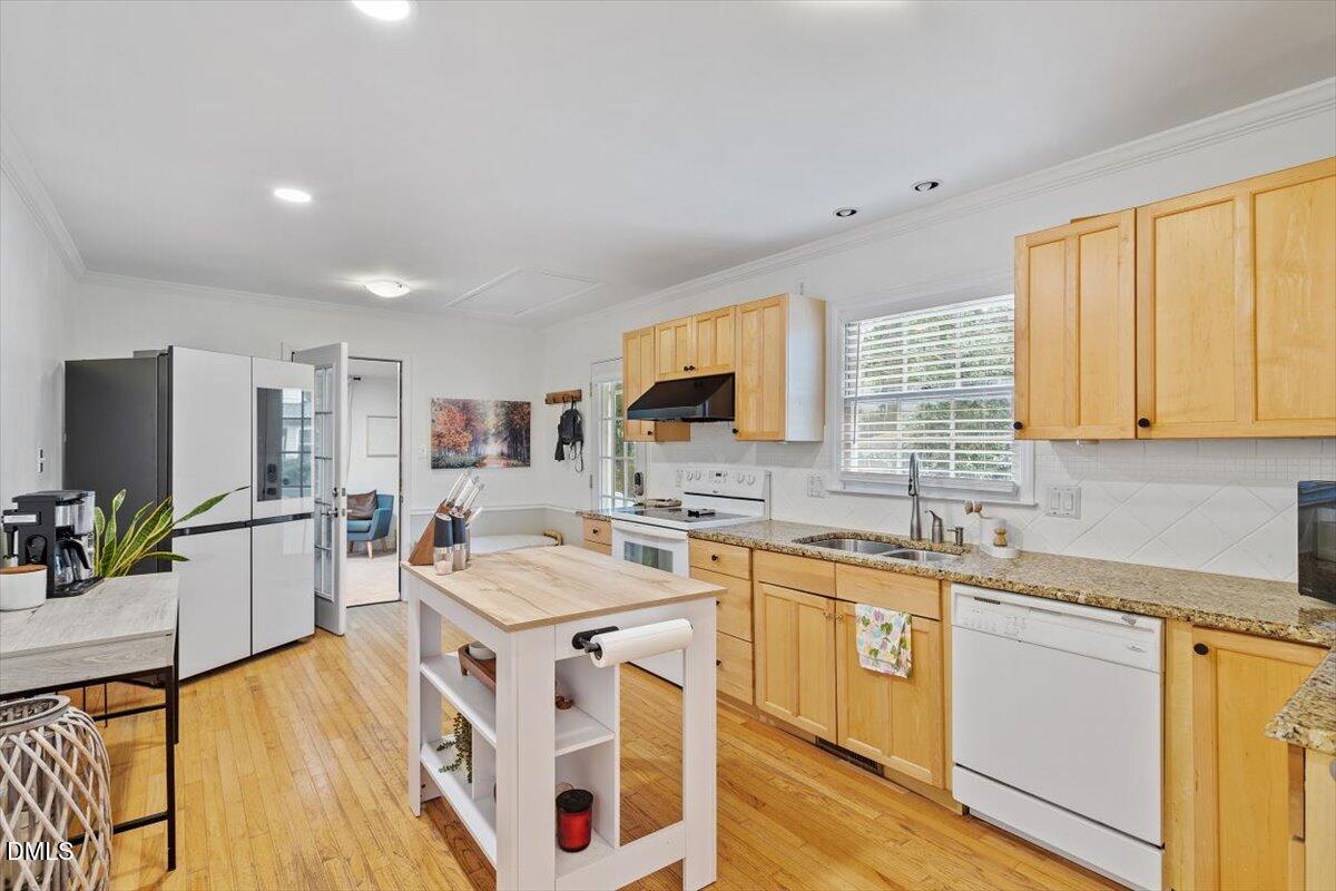 1007 Castalia Drive Cary, NC 27513 - Photo 16 of 30 a kitchen with stainless steel appliances granite countertop a sink stove cabinets and wooden floor