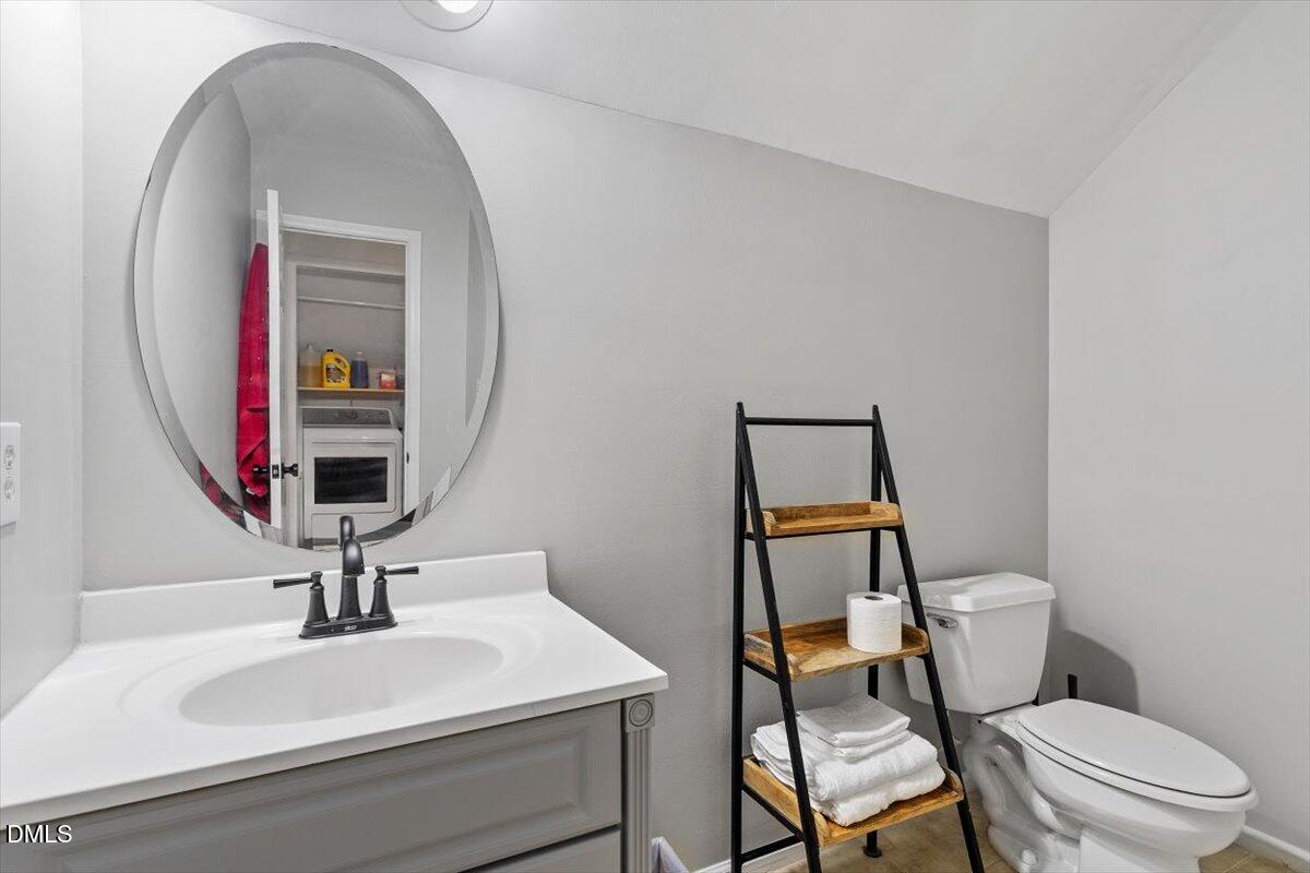 1007 Castalia Drive Cary, NC 27513 - Photo 25 of 30 a bathroom with a toilet a sink and mirror