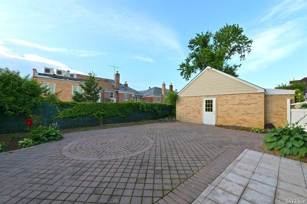 108-35 66th Road Queens, NY 11375 - Photo 3 of 19 a front view of a house with a yard and a garage