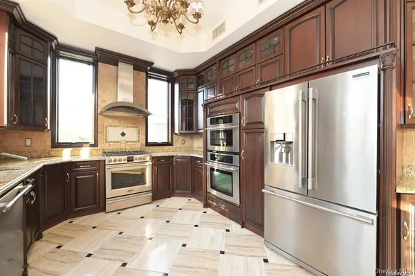 a large kitchen with a large window and stainless steel appliances