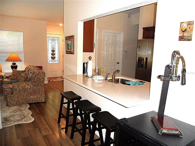 a kitchen with stainless steel appliances granite countertop a stove top oven a sink dishwasher a dining table and chairs with wooden floor