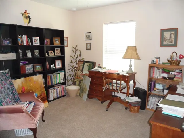 a living room with furniture and a book shelf