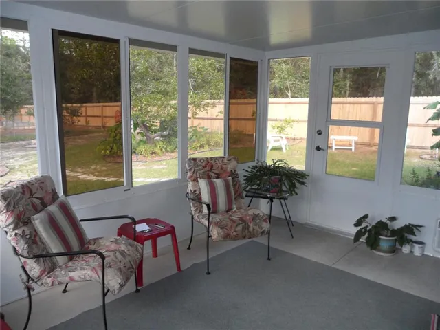 a living room with furniture and a floor to ceiling window