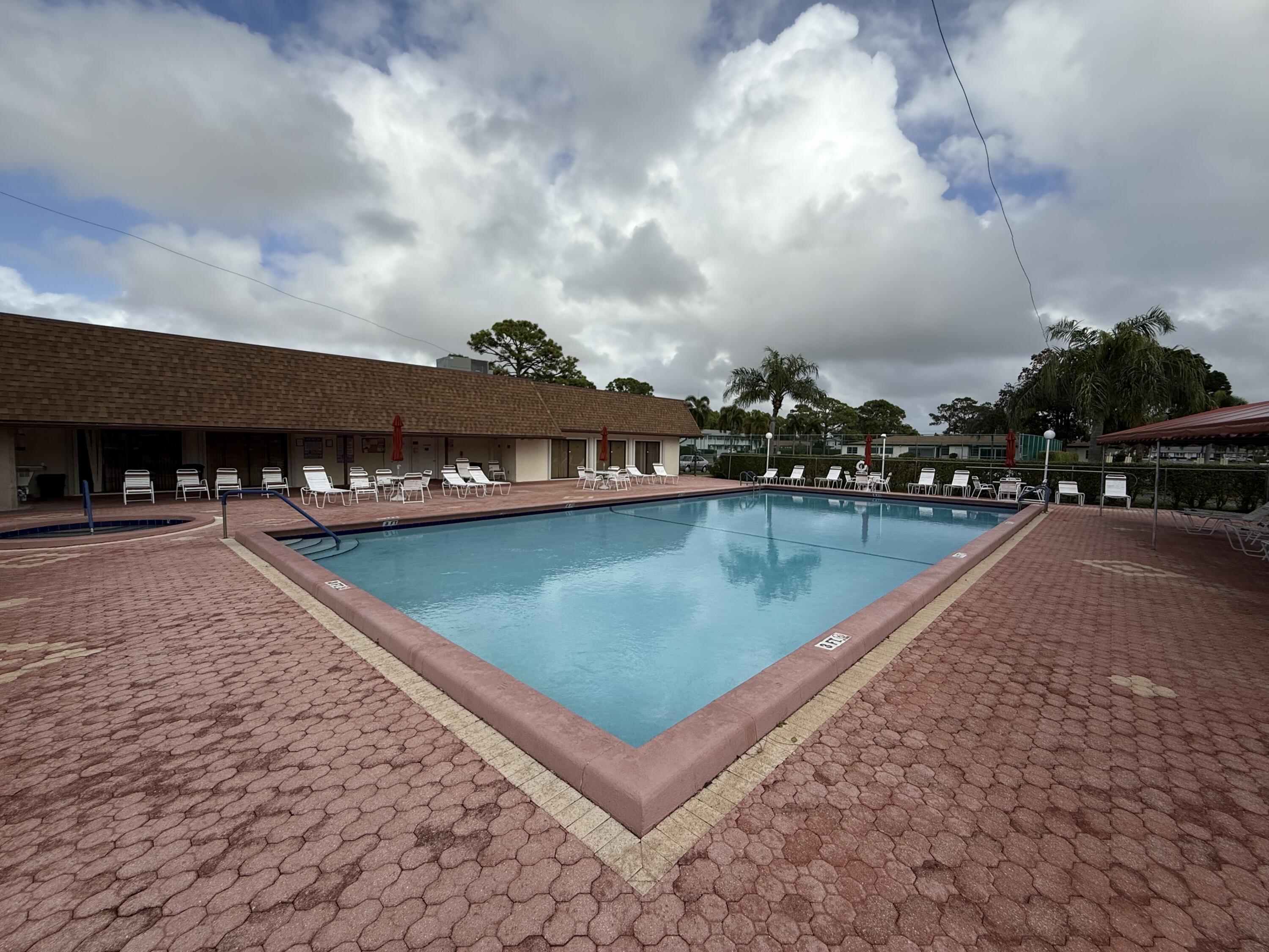 5139 Poppy Place, Unit A Delray Beach, FL 33484 - Photo 11 of 36 a view of a swimming pool with lawn chairs