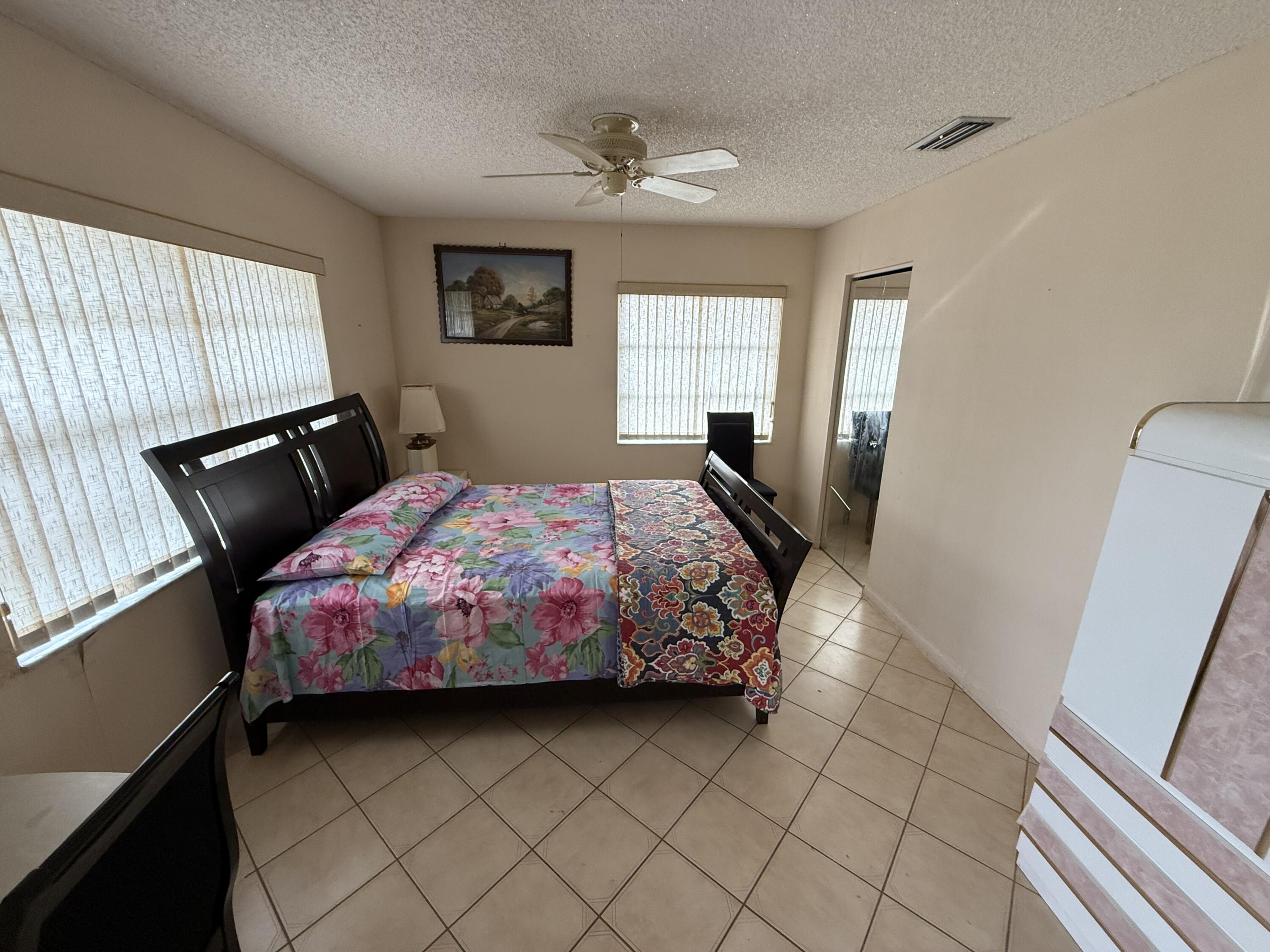 5139 Poppy Place, Unit A Delray Beach, FL 33484 - Photo 26 of 36 a bedroom with a bed and window