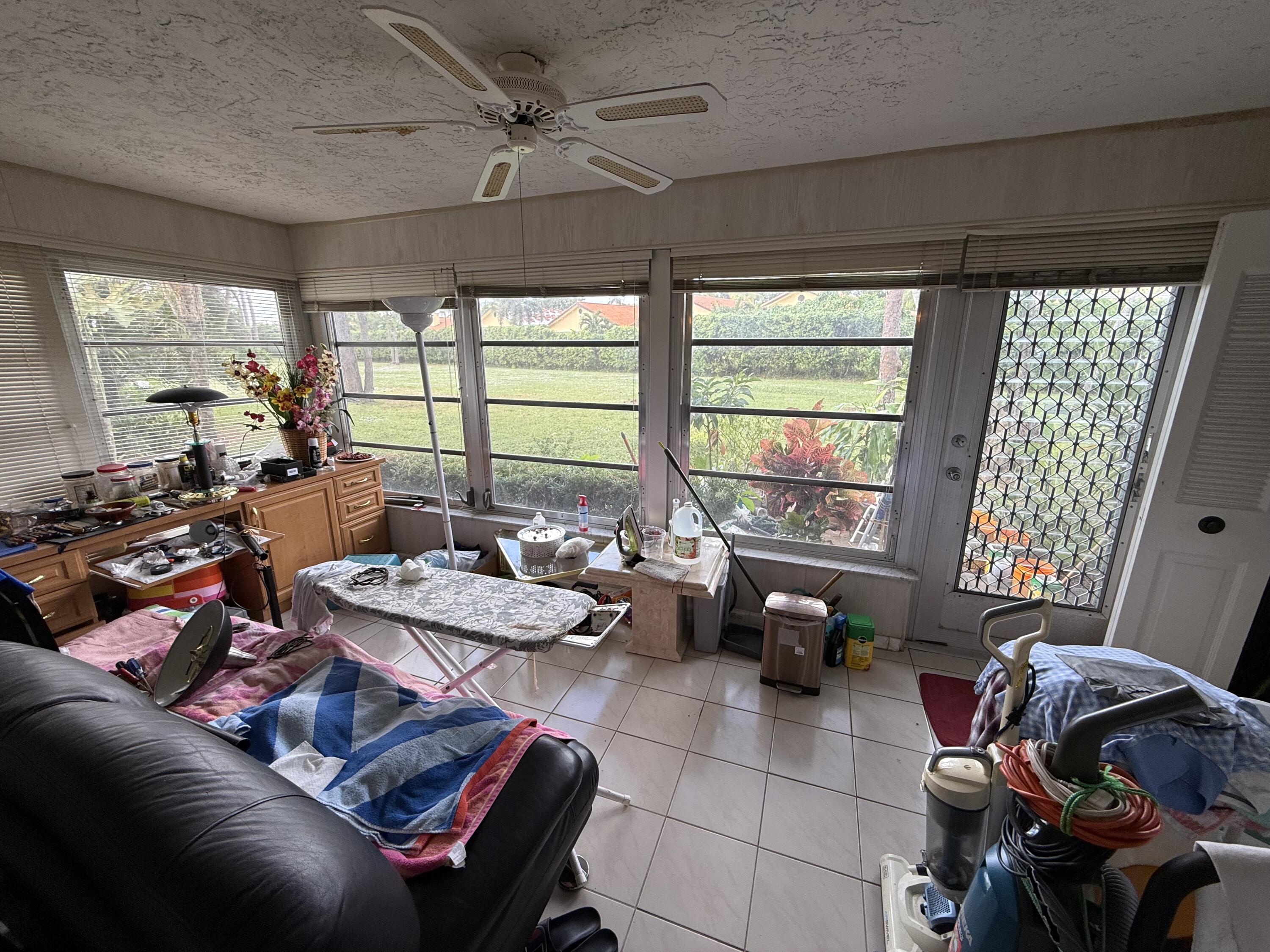 5139 Poppy Place, Unit A Delray Beach, FL 33484 - Photo 33 of 36 a living room with furniture and floor to ceiling windows