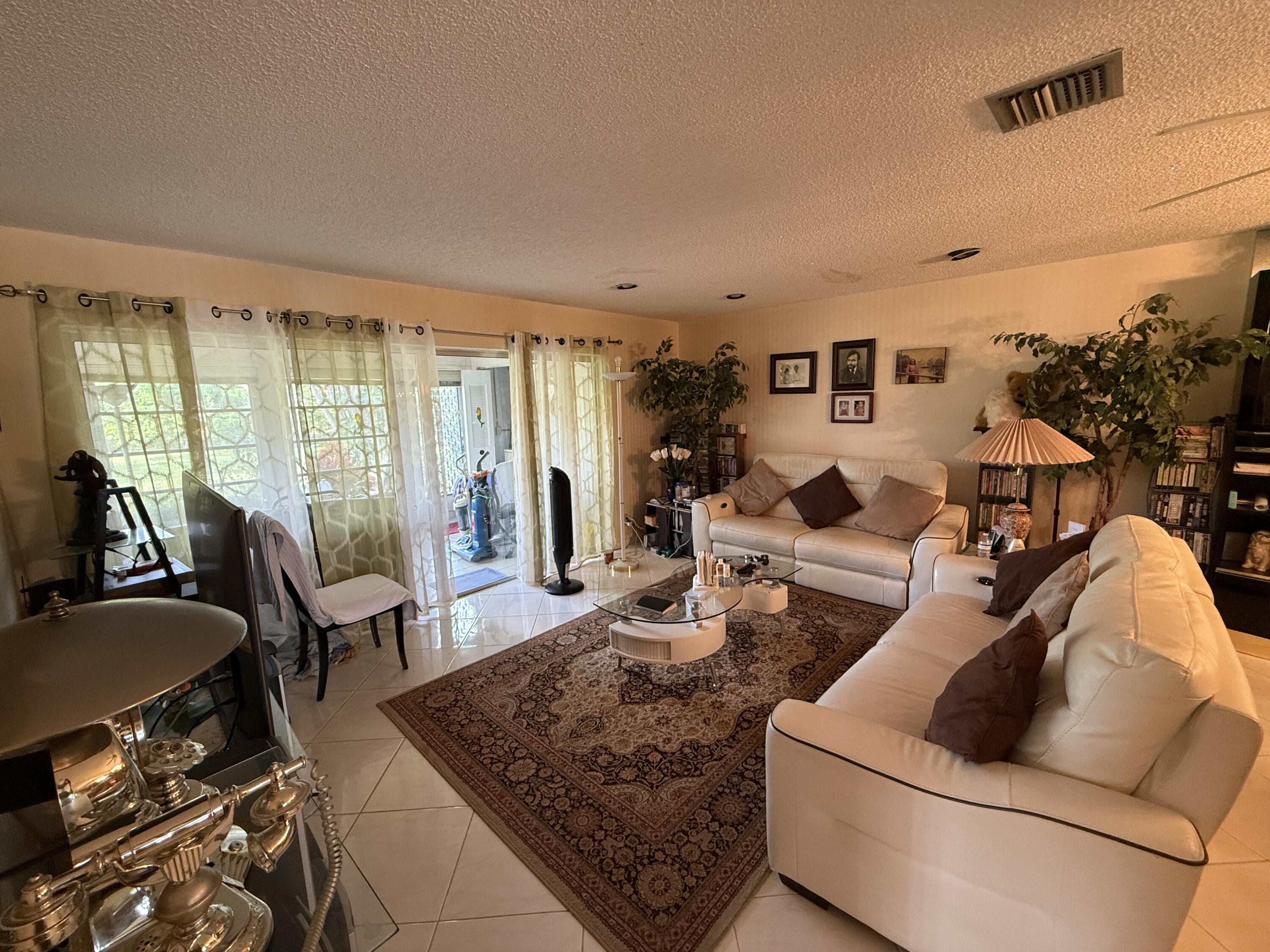 5139 Poppy Place, Unit A Delray Beach, FL 33484 - Photo 34 of 36 a living room with furniture and a couch
