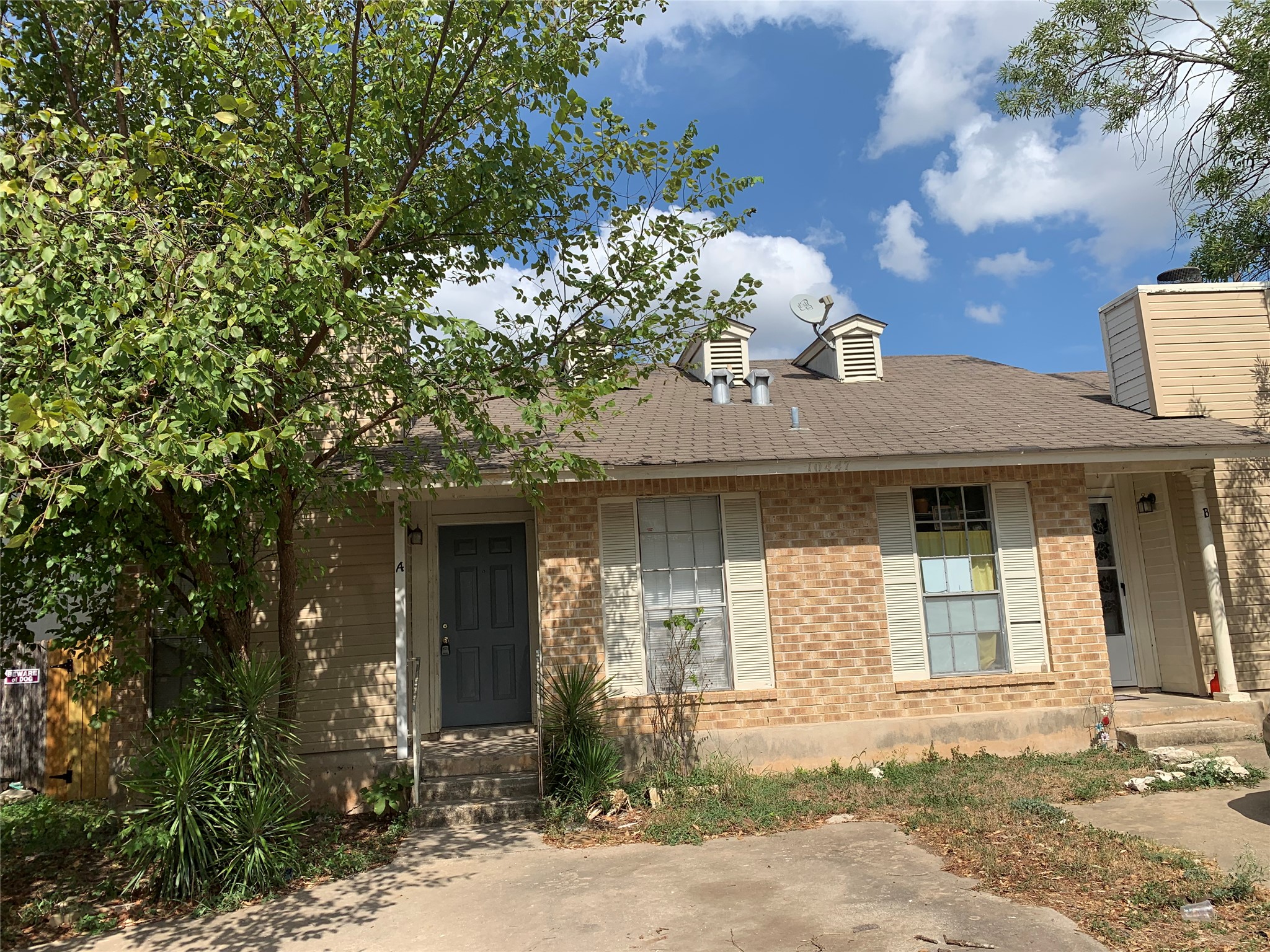 10447 Doc Holliday Trail, Unit B Austin, TX 78753 - Photo 19 of 19 View of front of house featuring covered porch, roof with shingles, and brick siding