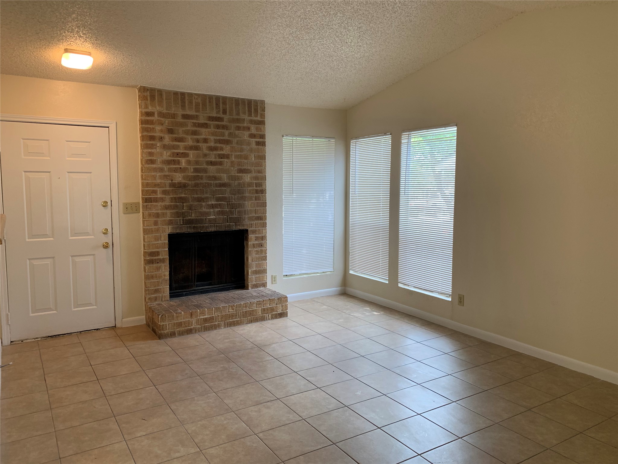 10447 Doc Holliday Trail, Unit B Austin, TX 78753 - Photo 8 of 19 Unfurnished living room with a fireplace and light tile patterned floors