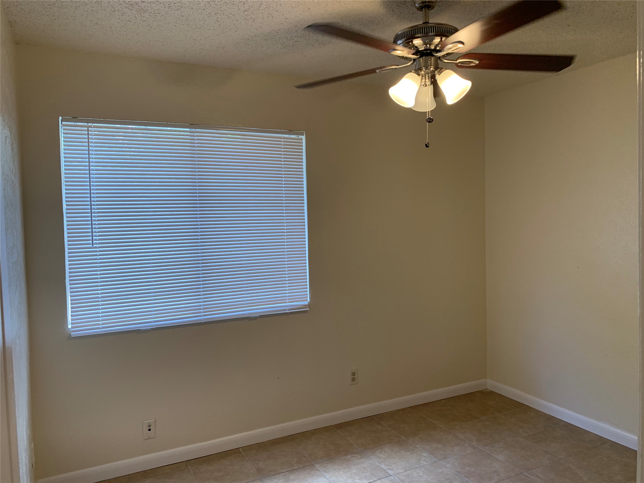 10447 Doc Holliday Trail, Unit B Austin, TX 78753 - Photo 10 of 19 Empty room with a textured ceiling, a ceiling fan, and light tile patterned floors